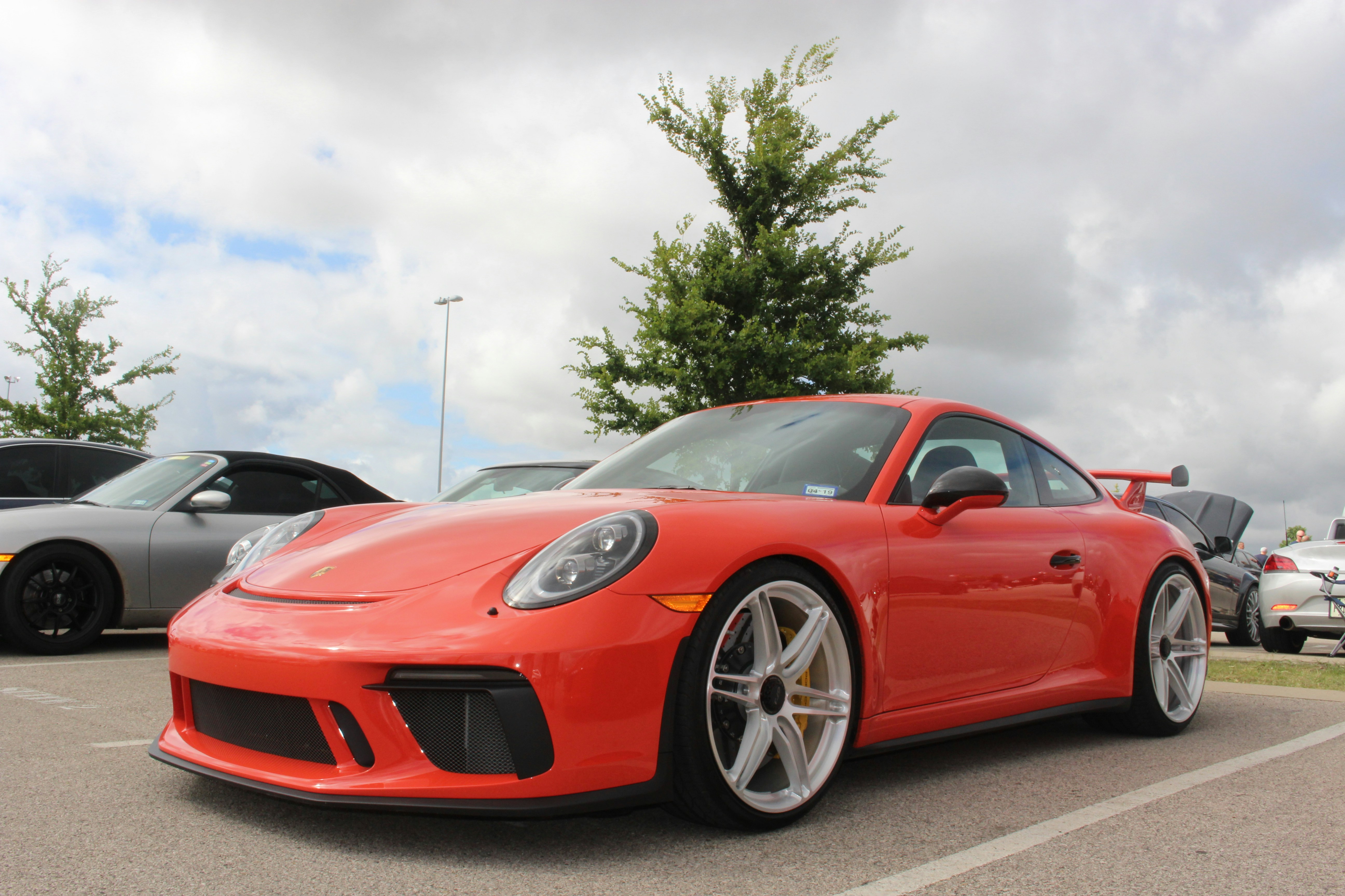 Ferrari 458 Italia Merah Diparkir di Jalan Aspal Abu-abu pada Siang Hari