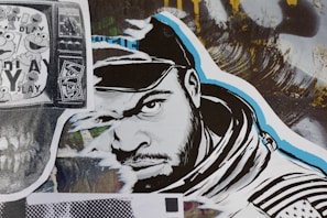 A stylized street art collage features a monochrome illustration of a man’s face wearing a hood. The artwork incorporates bold black and white lines with blue accents. To the left, a black and white print displaying cartoon characters overlaid on a TV screen adds a nostalgic element. A variety of textures and abstract backgrounds are present, contributing to a dynamic urban aesthetic.