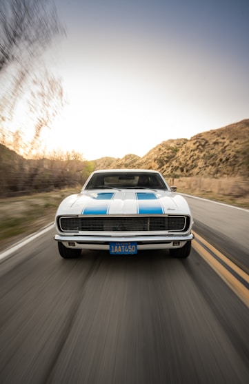 white and blue chevrolet camaro on road during daytime
