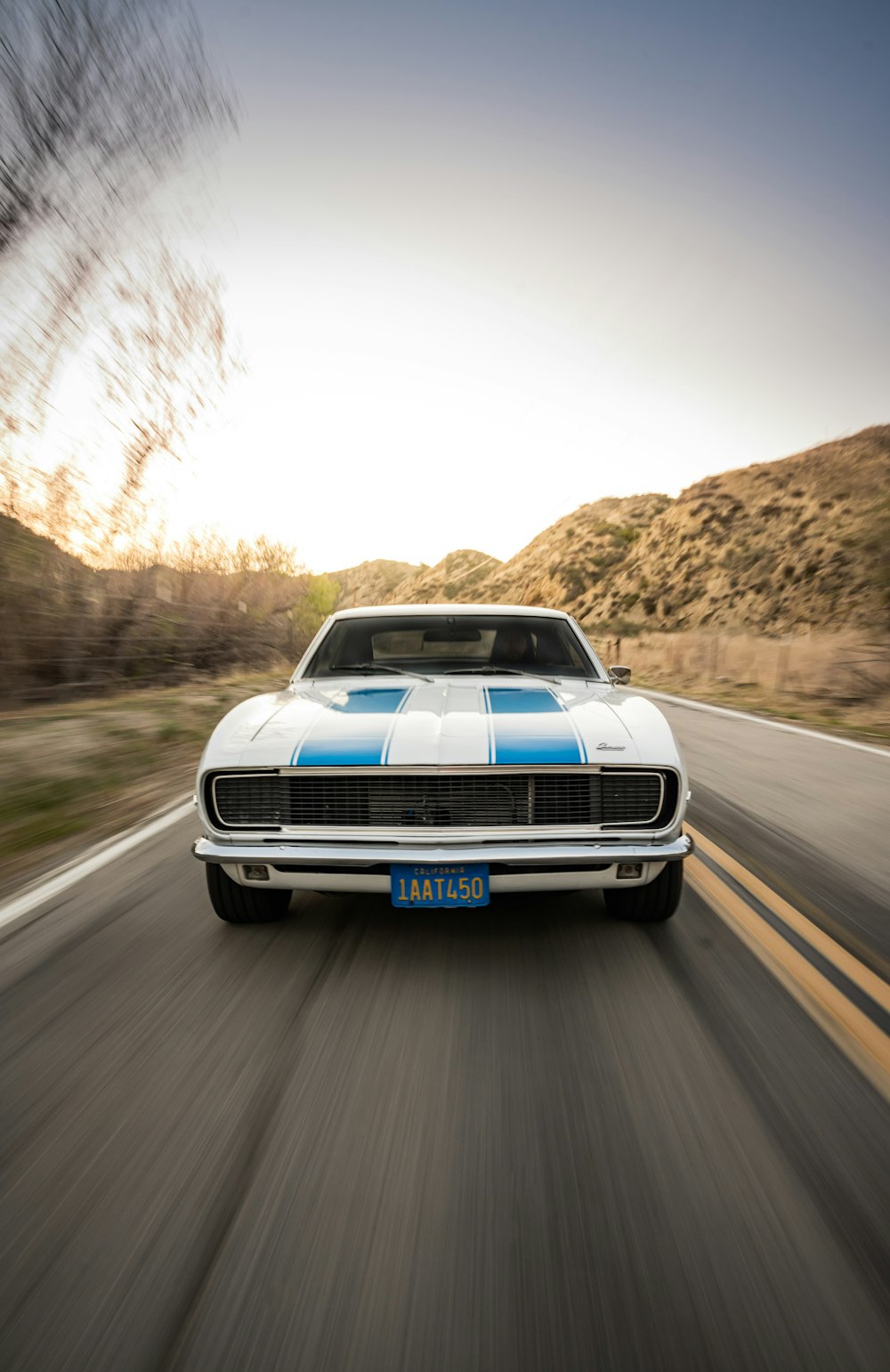 white and blue chevrolet camaro on road during daytime