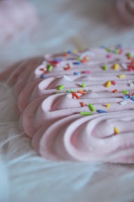 A close-up of a creamy dessert topped with colorful sprinkles.