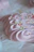 A close-up of a beautifully decorated pink cake with delicate frosting swirls.