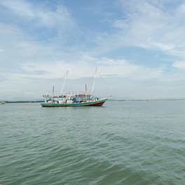 A sleek fishing vessel cruising through calm blue waters under a clear sky.