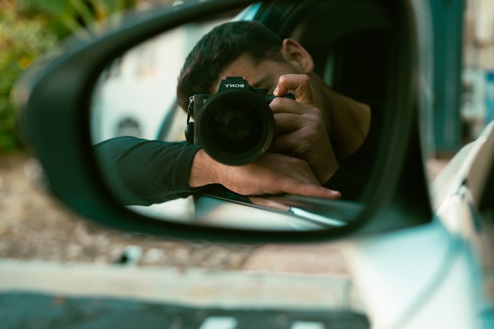 man in green long sleeve shirt holding black camera