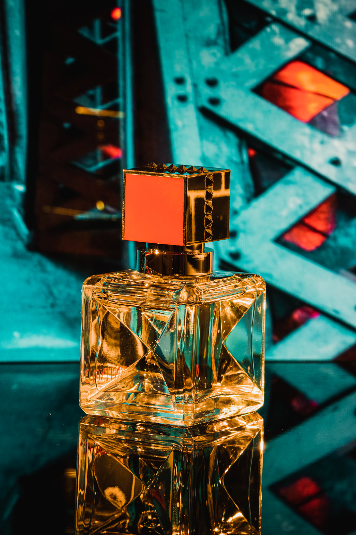 Frasco de perfume fresco sobre una superficie azul