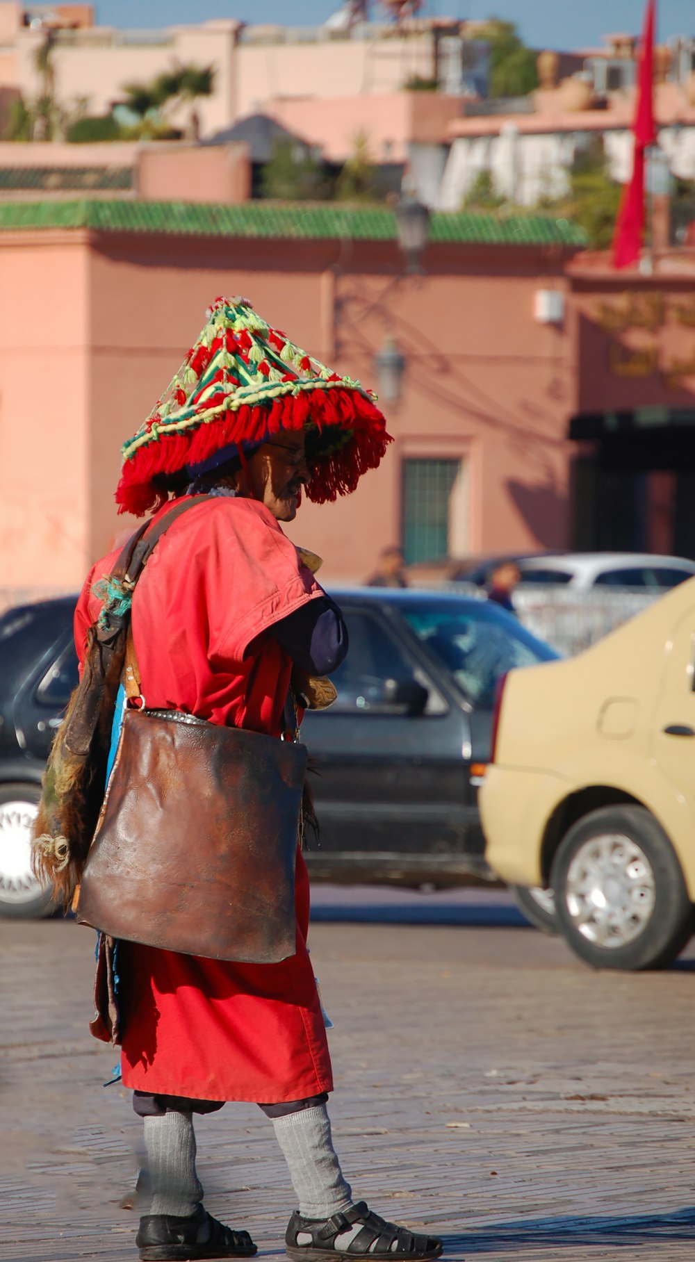 woman in red and black dress wearing red and white floral scarf standing on sidewalk during