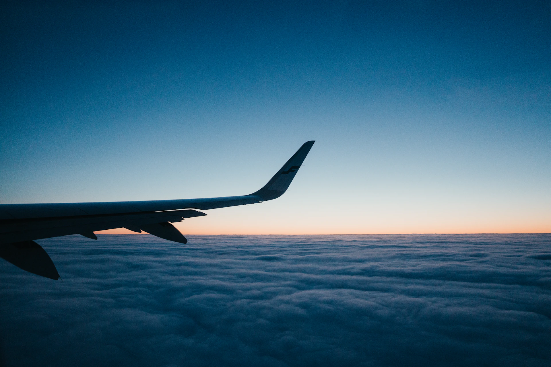 airplane wing over white clouds during daytime