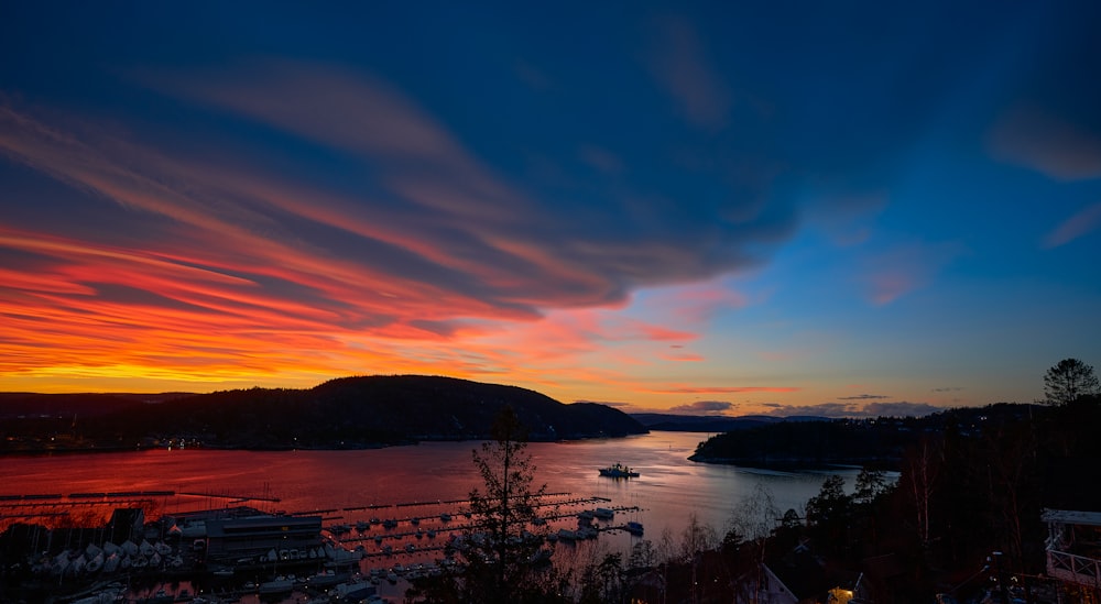 corpo de água perto de árvores durante o pôr do sol