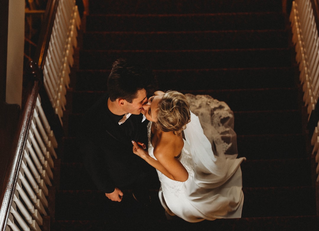 man in white shirt kissing woman in white dress