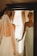 A bride admiring her elegant hairstyle in a softly lit salon mirror.