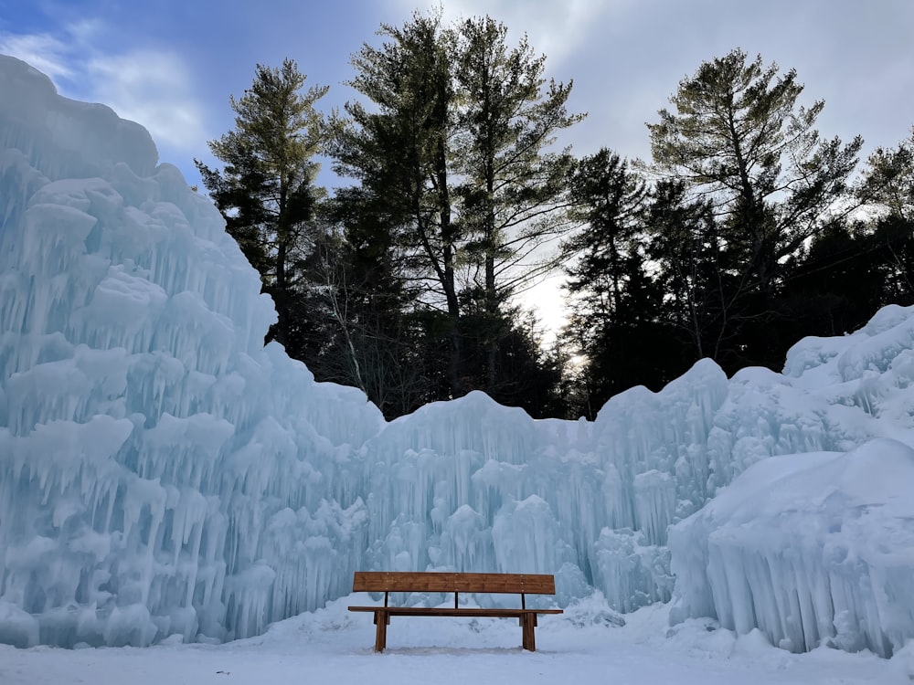 brown wooden bench covered with snow