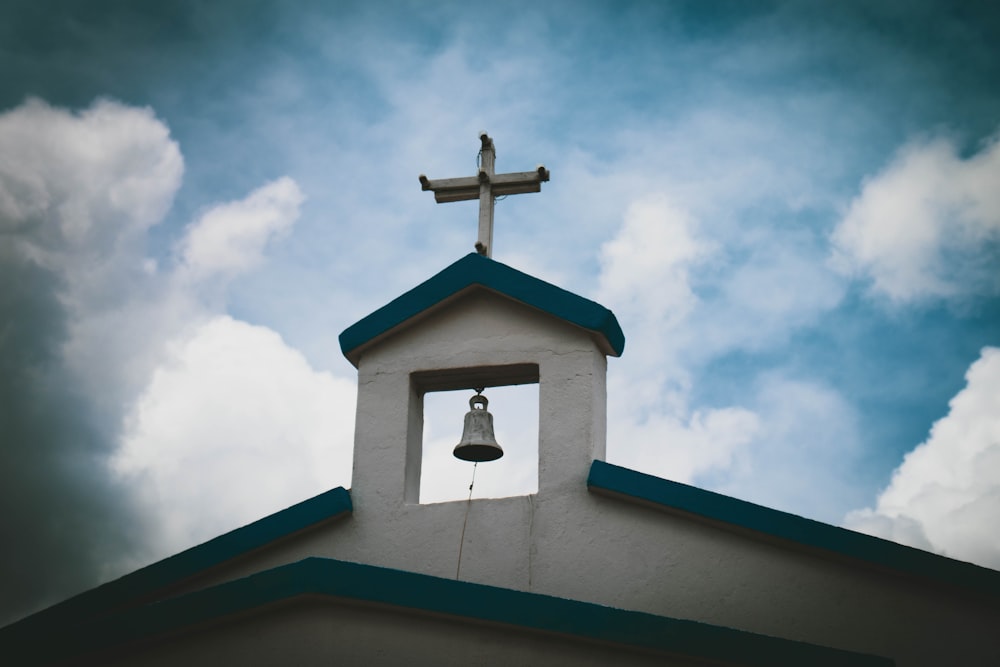 brown cross on top of roof under blue sky during daytime