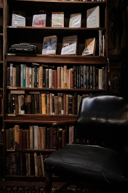 A warm, inviting reading nook bathed in soft cream light with a stack of books and a vintage typewriter.