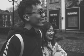 A candid shot of two people exchanging smiles on a city street