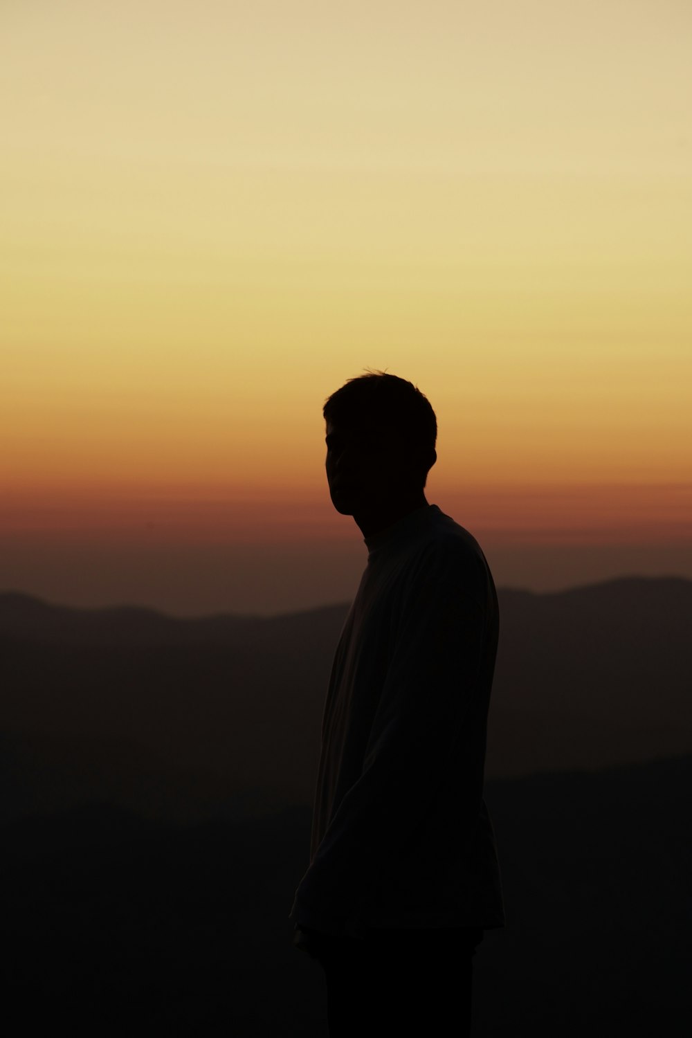 silhueta do homem em pé durante o pôr do sol