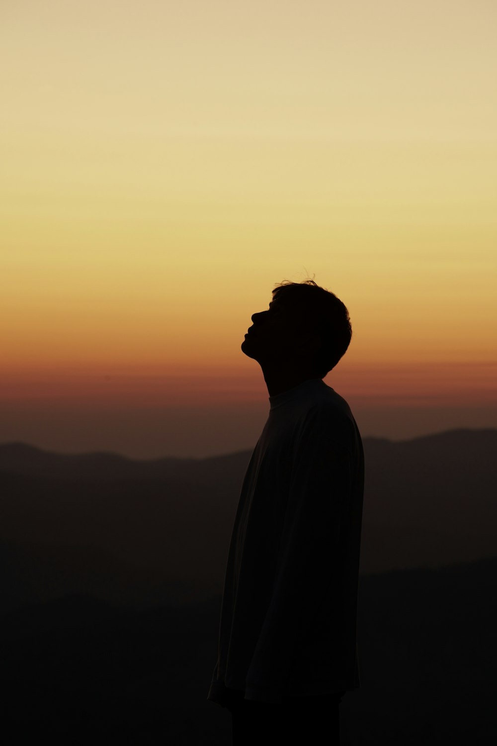 Silhouette de la personne debout au coucher du soleil