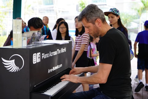 man in black t-shirt playing piano