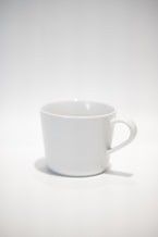 white ceramic mug on white table