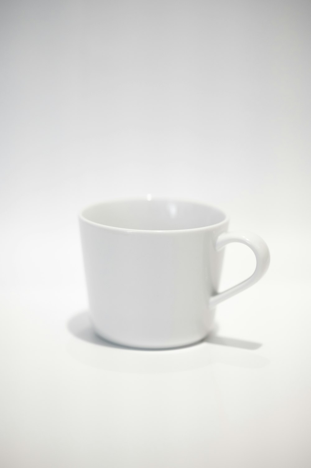 white ceramic mug on white table