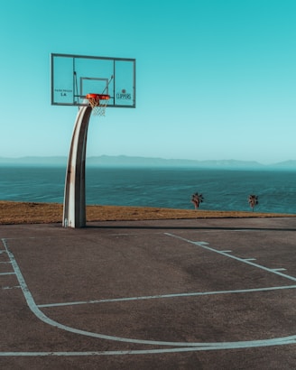 white and red basketball hoop on gray asphalt road during daytime