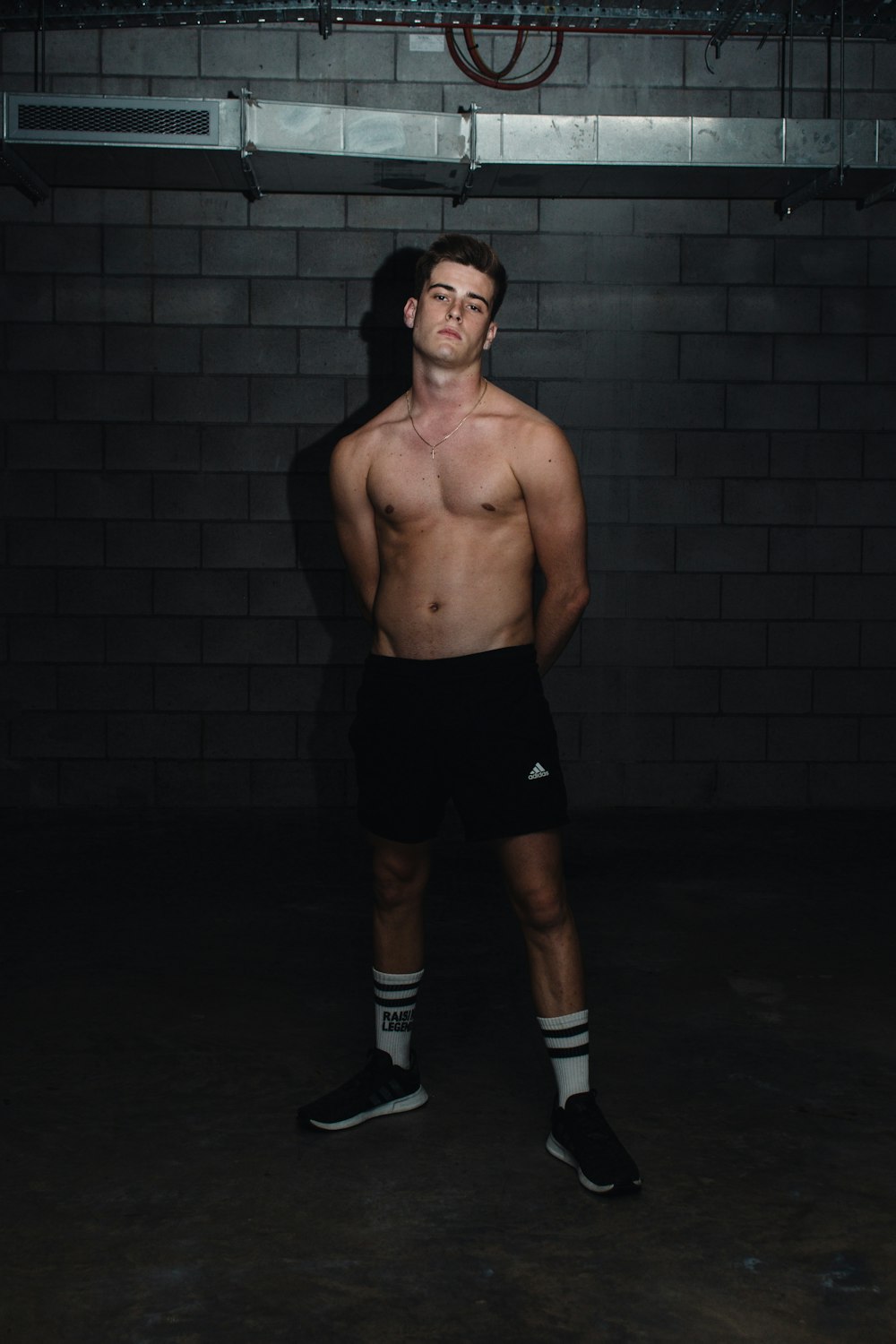 topless man in black shorts and white socks