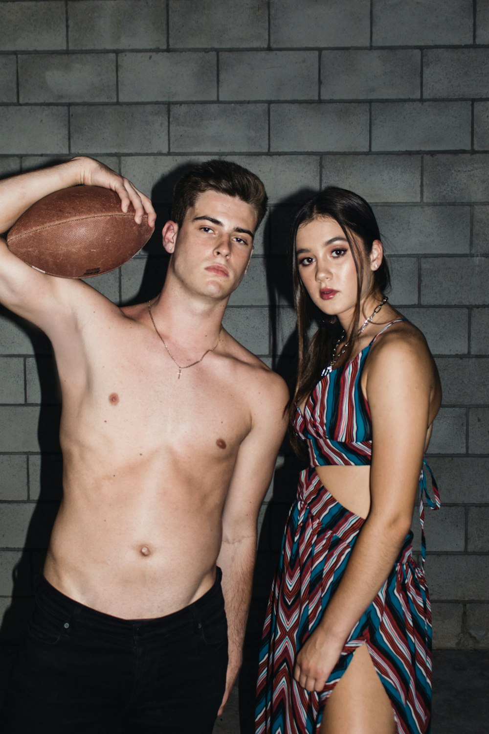 topless man and woman holding brown basketball
