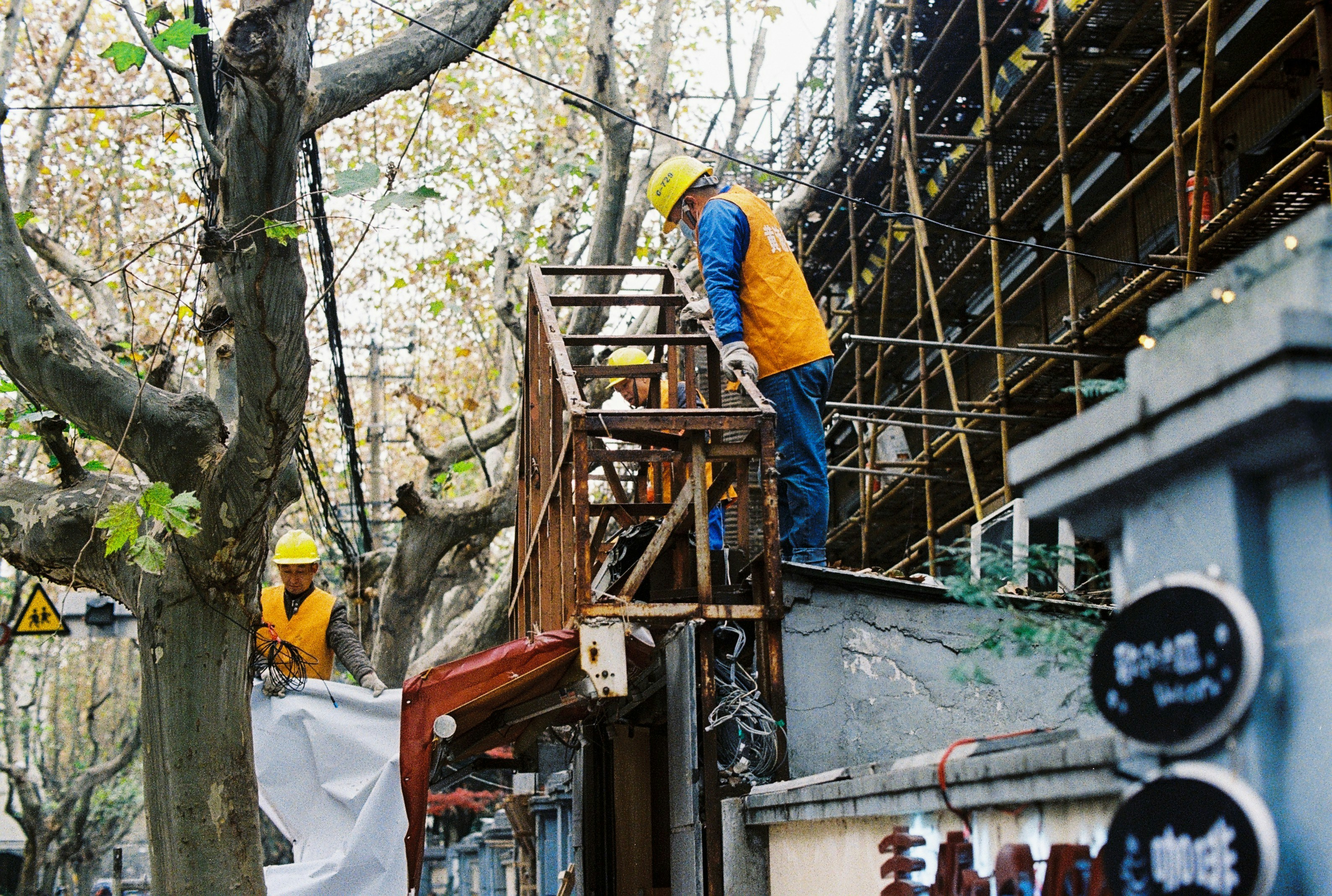 man in yellow hard hat and white long sleeve shirt climbing on ladder