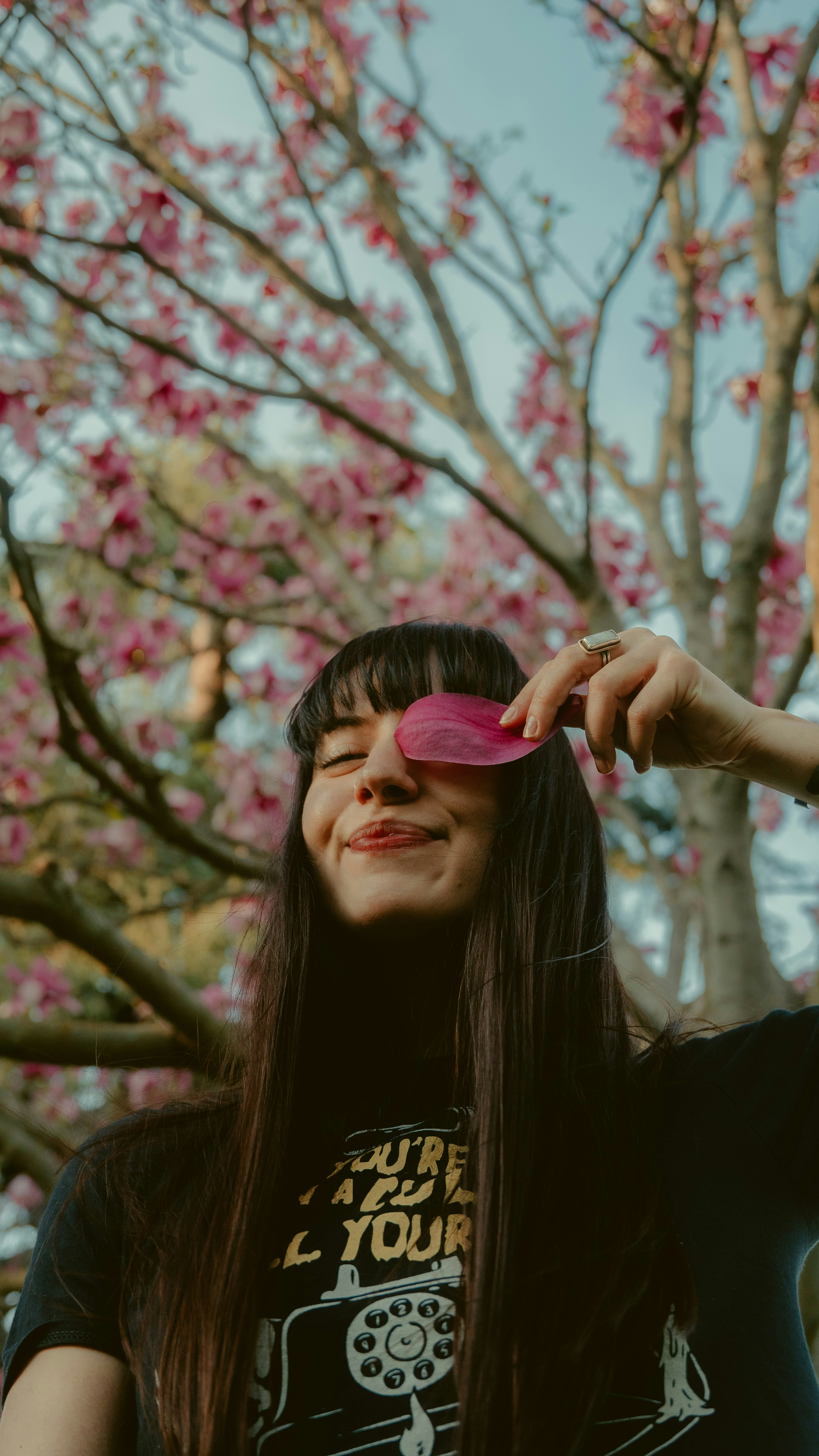 Mujer con camisa negra sosteniendo adorno de corazón rosa