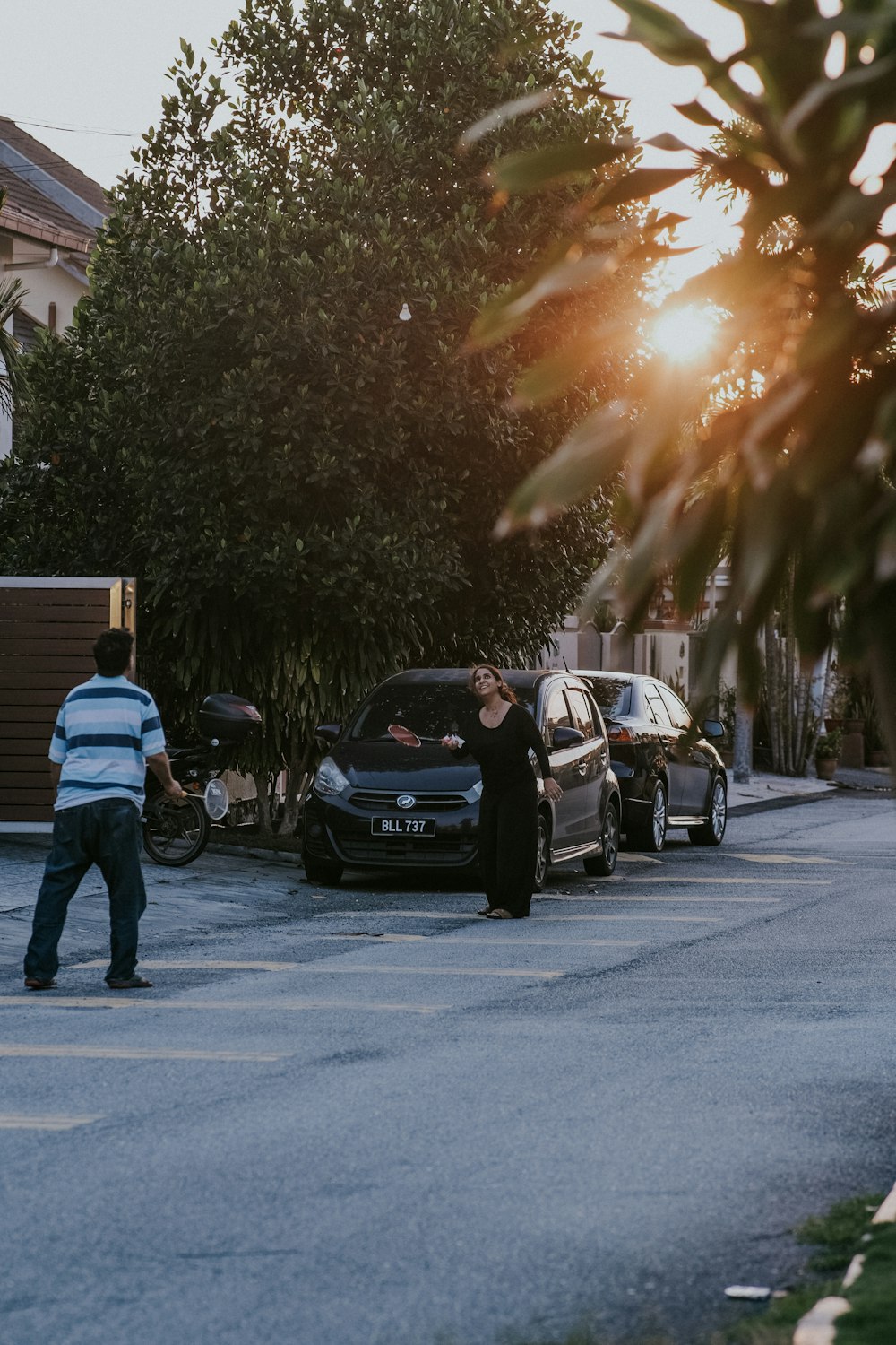 man in blue jacket standing beside black car during daytime