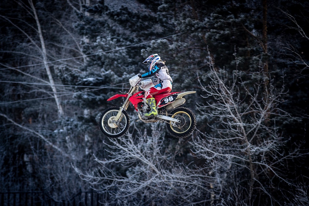 man in red and white motocross suit riding motocross dirt bike