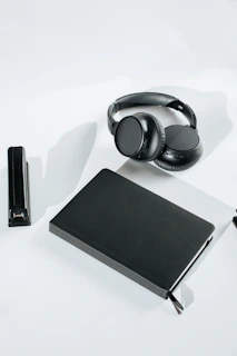 A stack of notes and legal documents next to headphones on a wooden table.