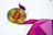 A Bitcoin coin with a red symbol is placed on a colorful geometric abstract background. The background features various shades of purple and pink geometric shapes, creating a dynamic and modern visual effect.