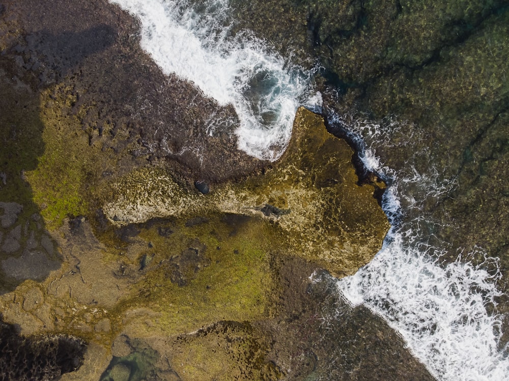 water waves hitting brown rocks