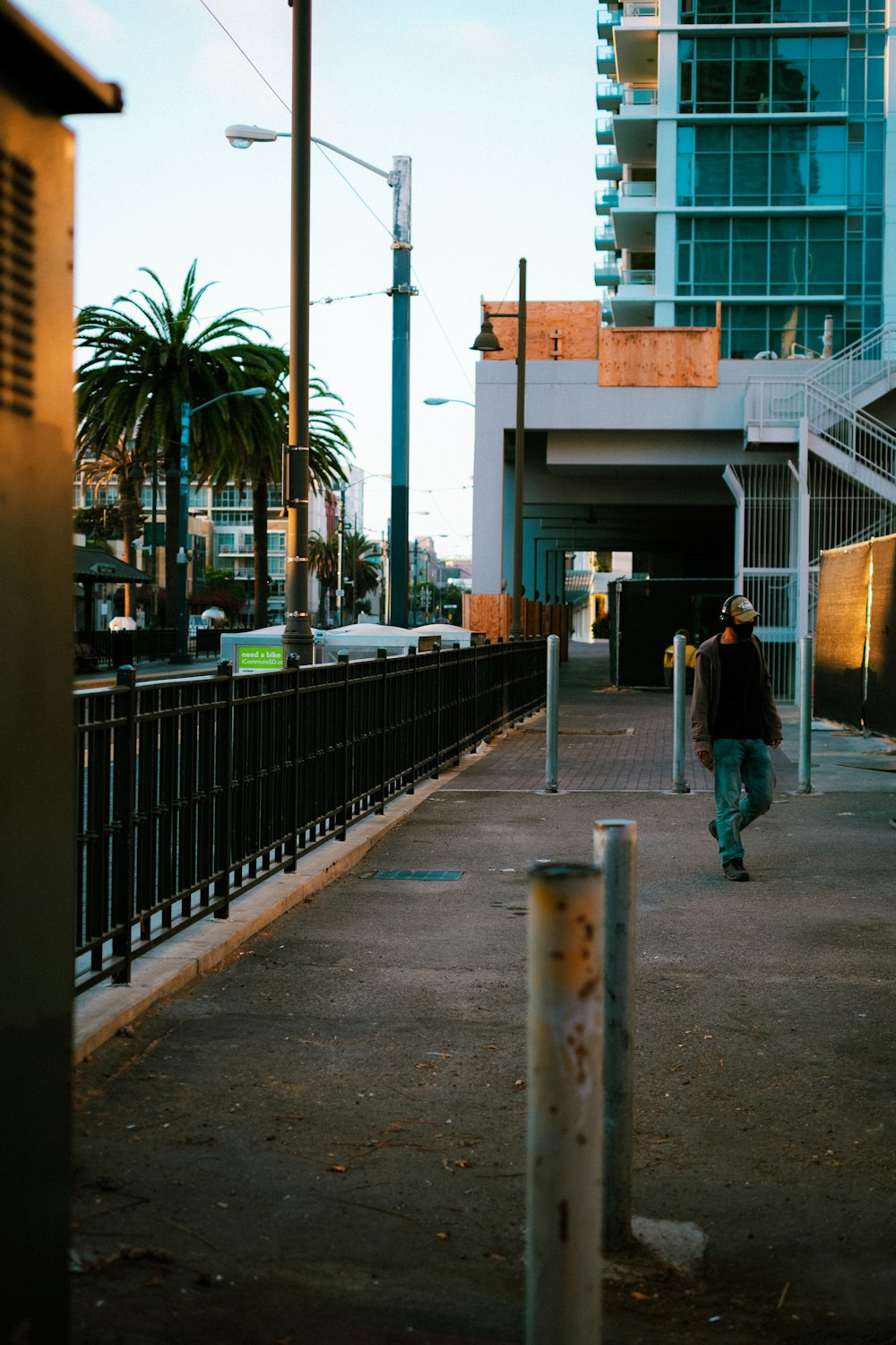 man in blue jacket walking on sidewalk during daytime