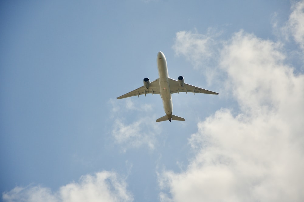 white airplane flying in the sky during daytime