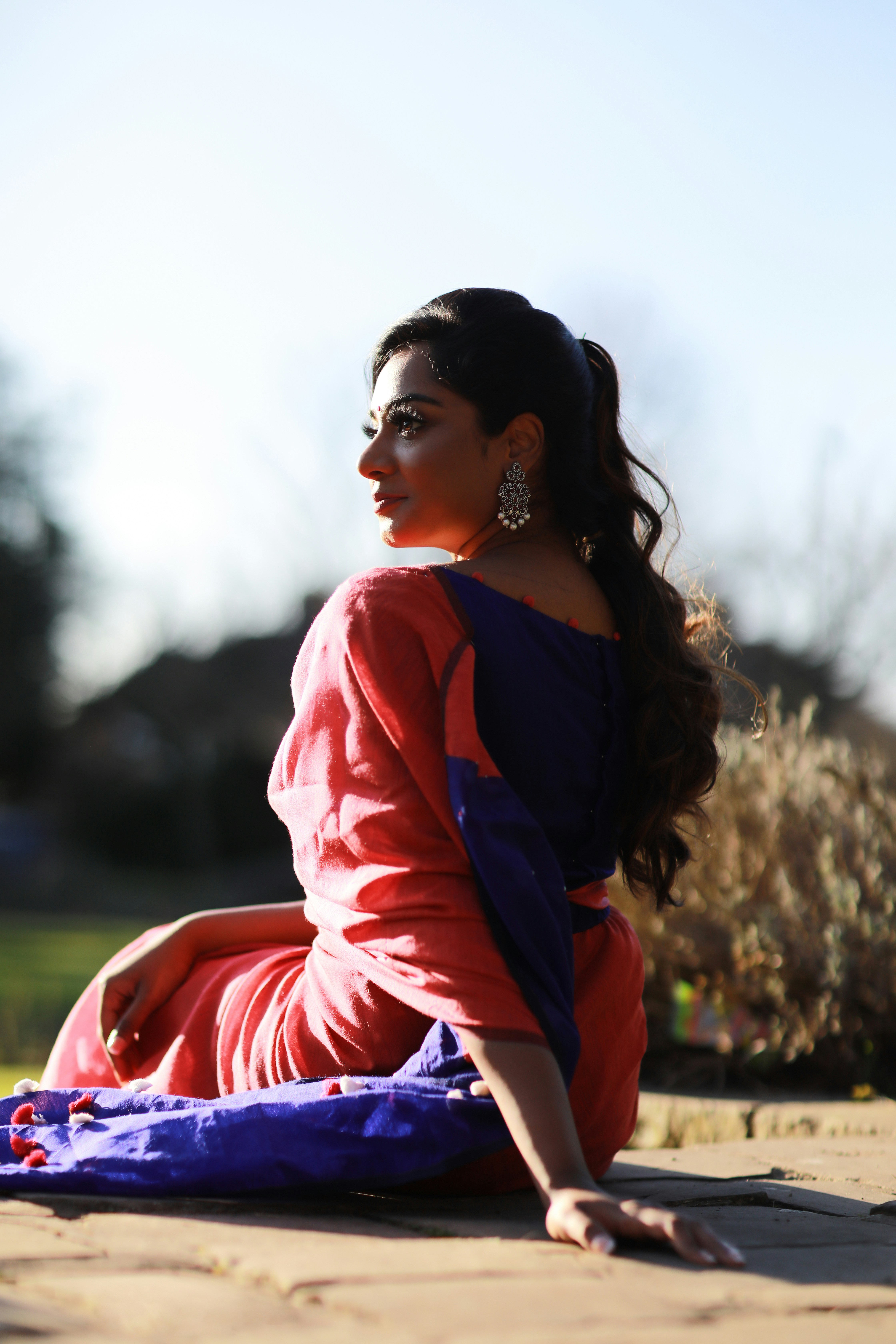 woman in red and blue long sleeve shirt standing on green grass field during daytime