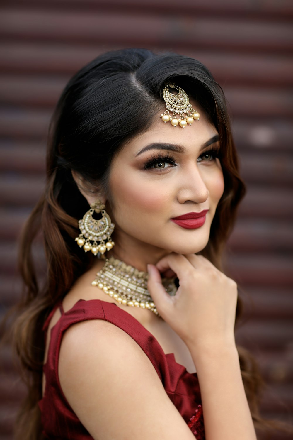 woman in red sleeveless top wearing gold and silver crown