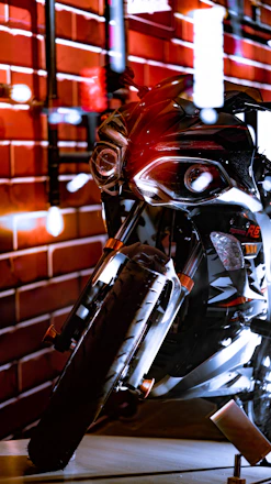 A powerful Harley Davidson motorcycle shining under dramatic red and black lighting.