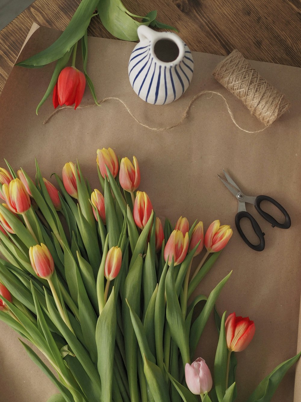 red and yellow tulips on brown wooden table