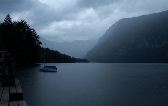 blue boat on body of water near mountain during daytime in Bohinjska Bistrica Slovenia