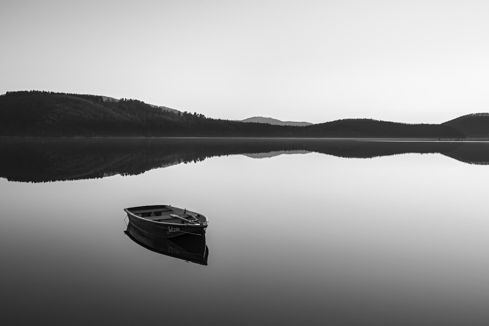 Boot auf ruhigem Wasser in der Nähe von Bergen während des Tages