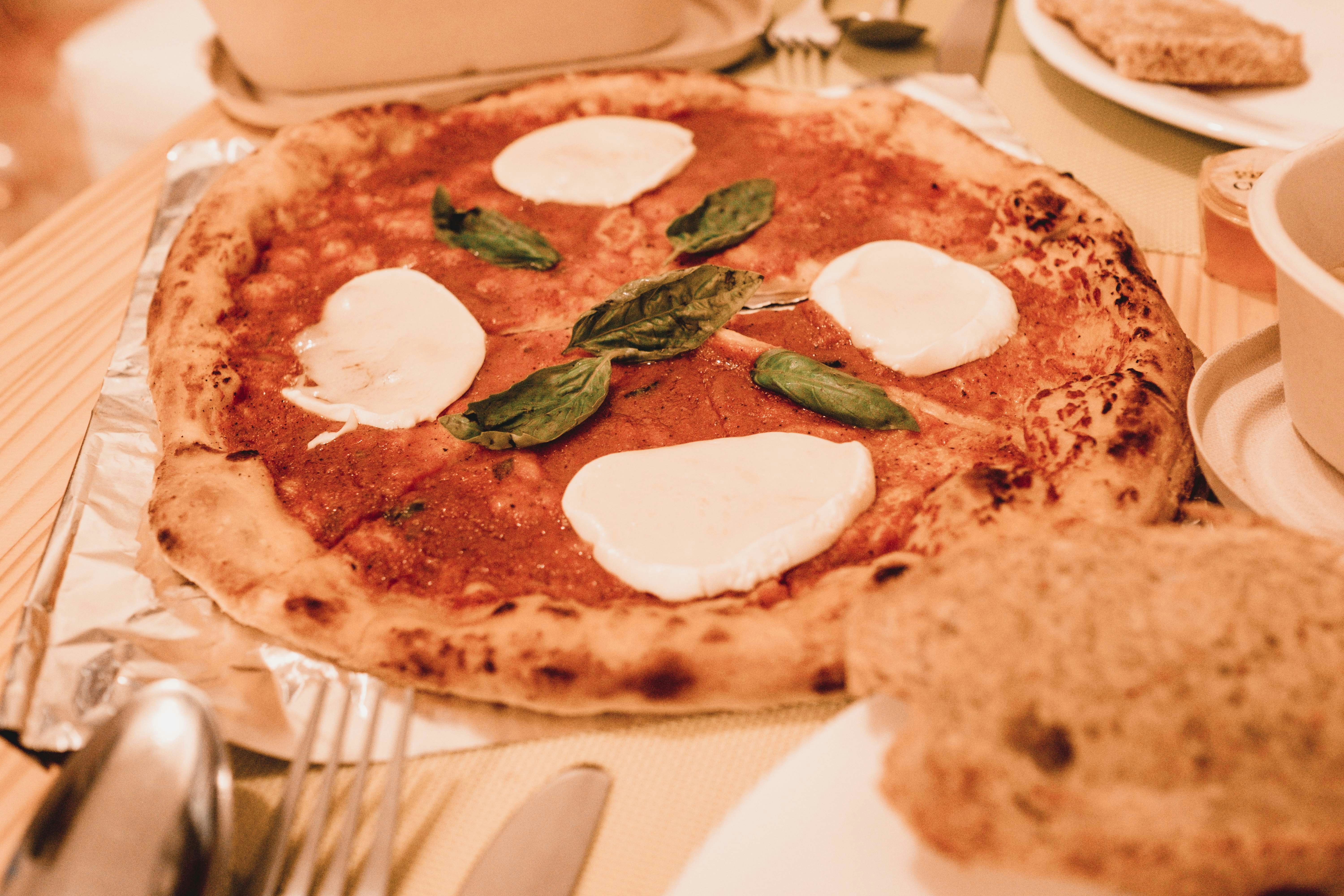 Classic margherita pizza with fresh mozzarella and basil on stone baked crust, overhead shot