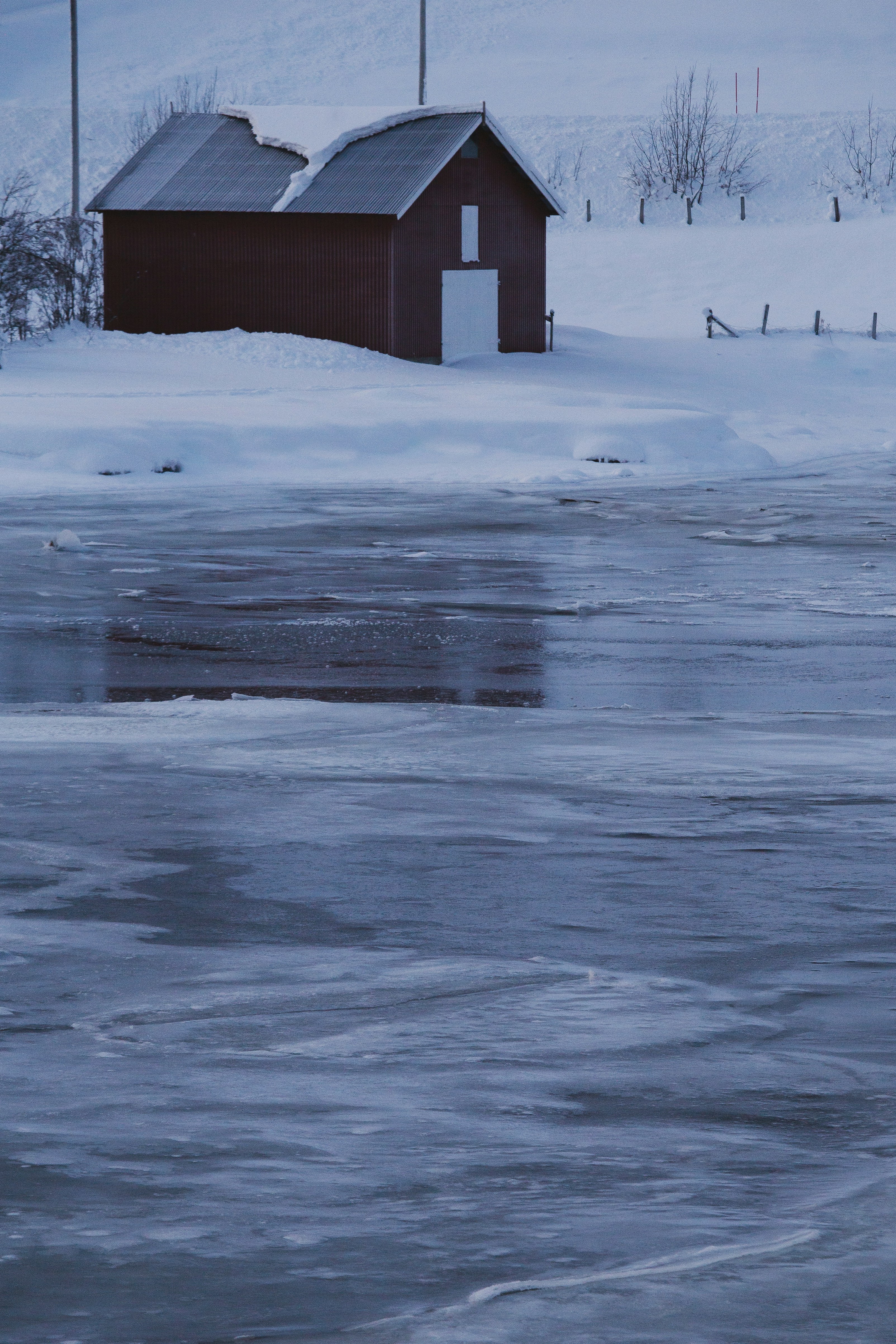 brown wooden house on snow covered ground during daytime