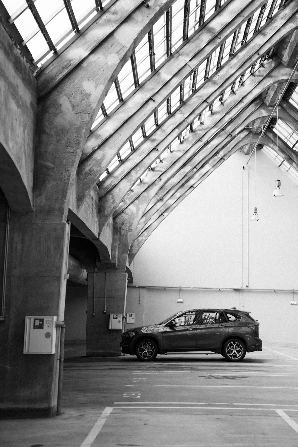 grayscale photo of car parked in tunnel