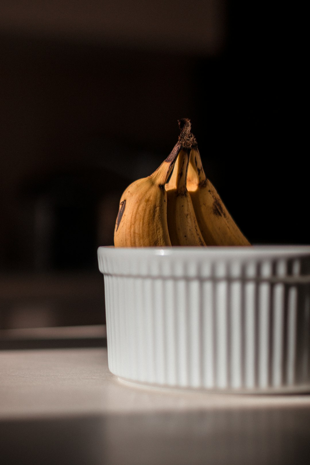 yellow and brown fruit on white ceramic bowl