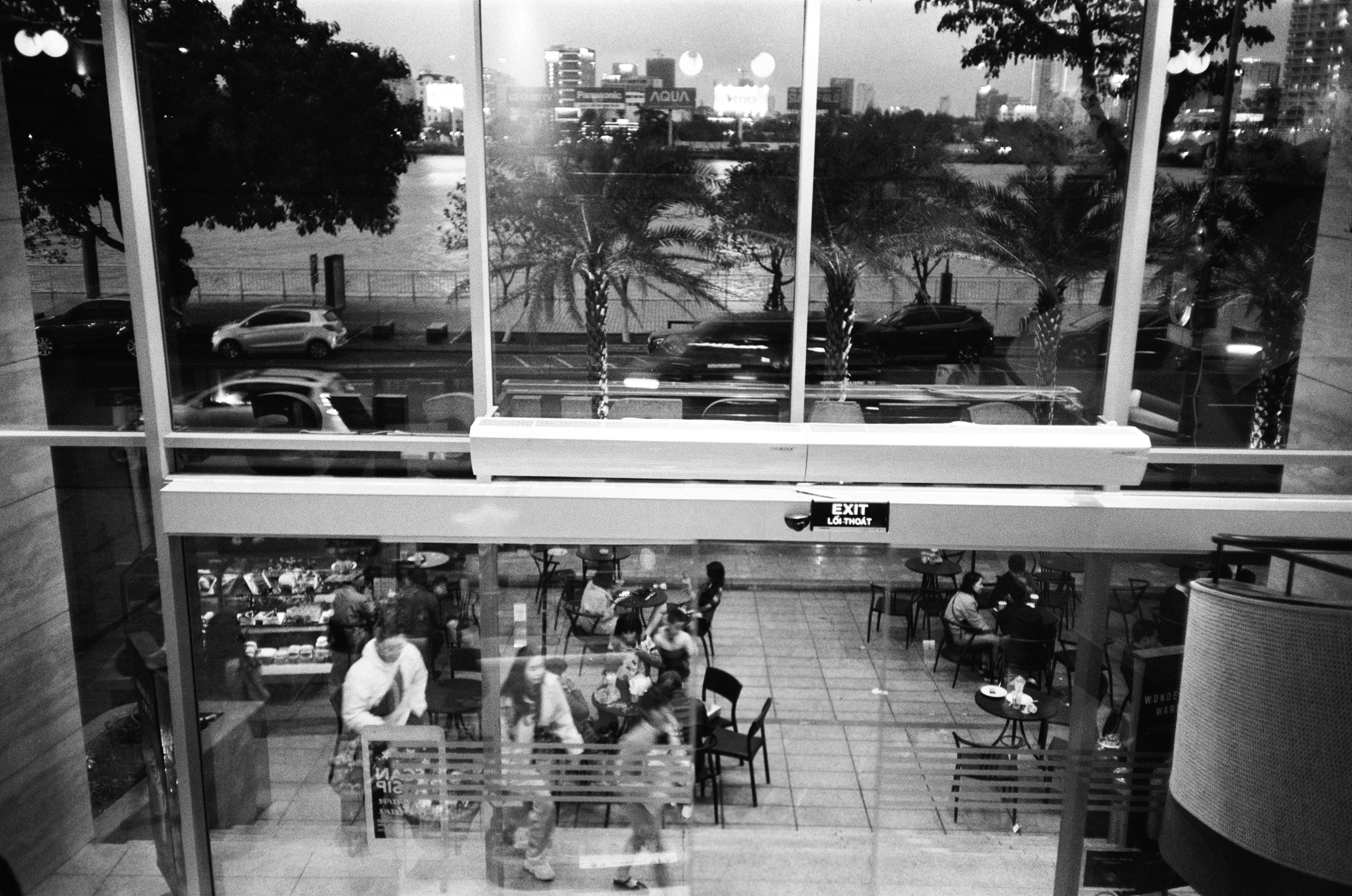 people sitting on bench in grayscale photography