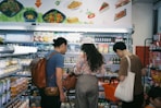 woman in brown long sleeve shirt and gray pants standing in front of white counter