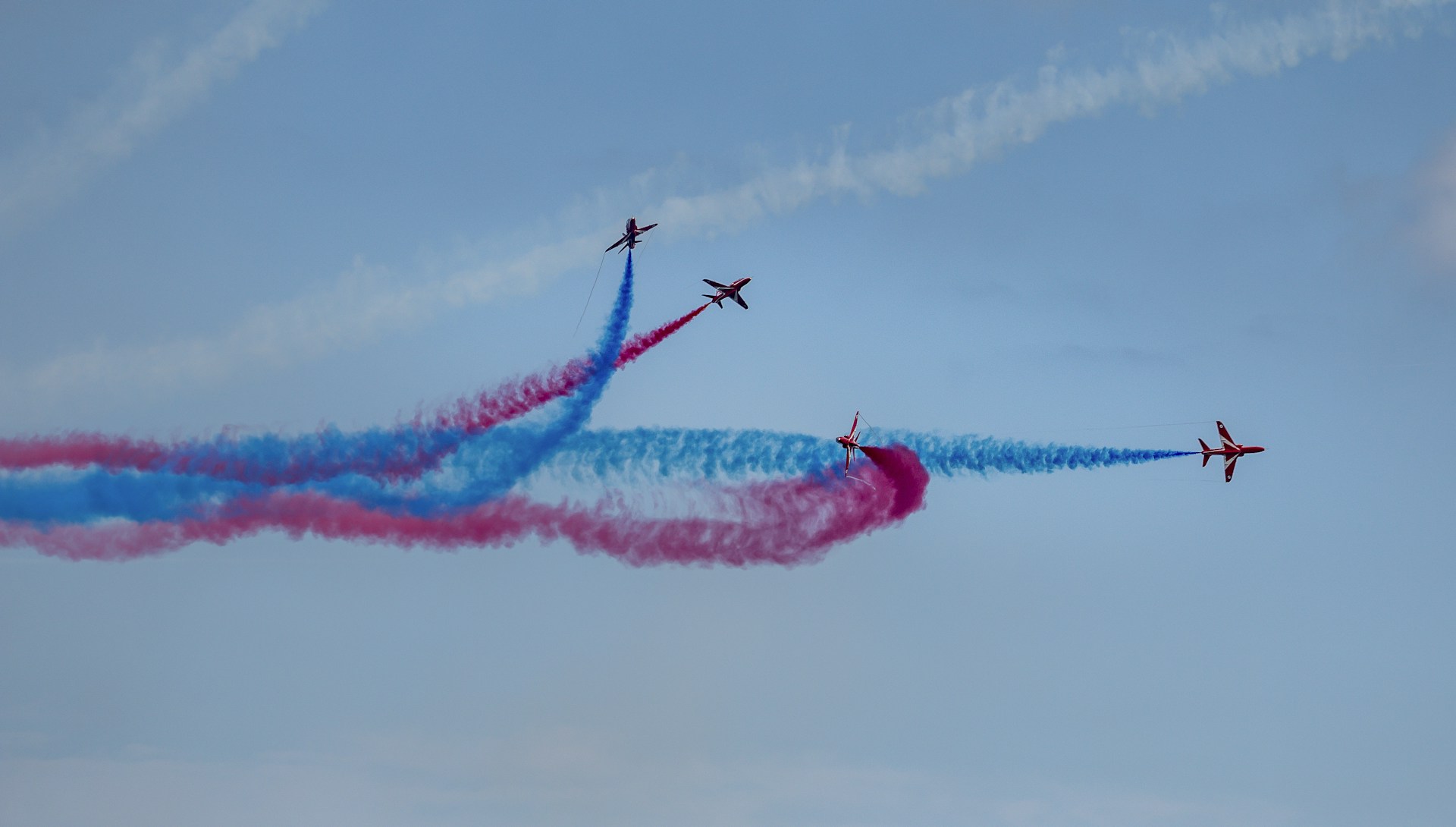 3 person riding on red and white plane under blue sky and white clouds during daytime