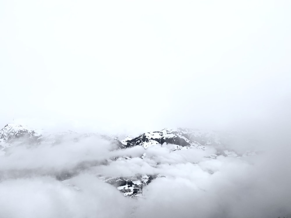 white clouds over snow covered mountain