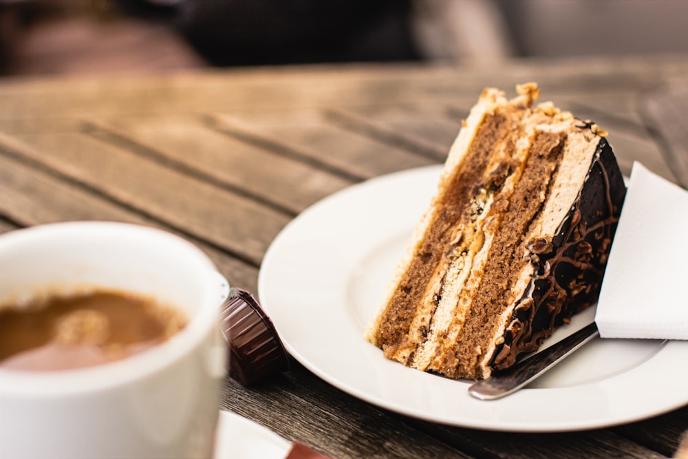 brauner und schwarz geschnittener Kuchen auf weißem Keramikteller